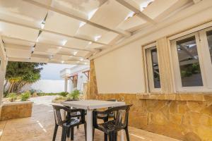 a patio with a table and chairs under a ceiling at Residence Dolce Vita in Torre Lapillo