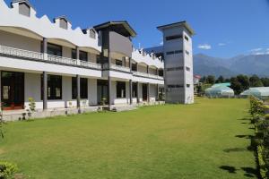 帕拉姆普爾的住宿－The Grand Kartikeye Hotel & Banquet Destination，享有大楼前方的景致,设有大草坪