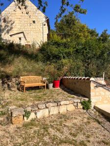 un banc en bois assis dans une cour à côté d'un mur de briques dans l'établissement Gîte du château, à Thizay
