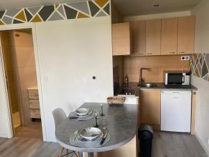 a small kitchen with a table and a microwave at La Pause Pétillante in Sélestat