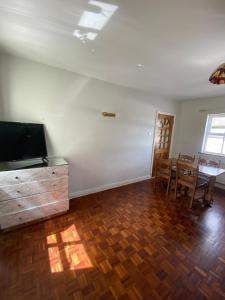 a living room with a television and a table and chairs at Beautiful 2-Bed Apartment in Lisselton
