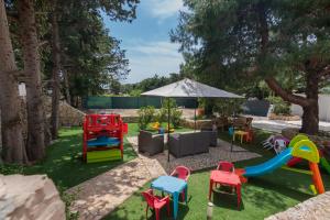 un parque infantil con sillas coloridas y un tobogán en Residence Dolce Vita, en Torre Lapillo