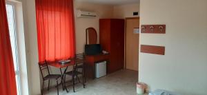 Habitación pequeña con mesa pequeña y cortina roja en Hotel Morski Dar, en Kranevo