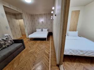 ein kleines Zimmer mit 2 Betten und einem Sofa in der Unterkunft У центрі 2 кімнатна квартира біля ЦУМу з власною закритою парковкою. Мережа Alex Apartments in Poltawa