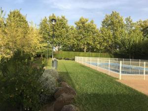 a tennis court with a fence and a pool at Las cerezas in Ciudad Real
