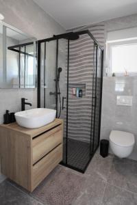 a bathroom with a sink and a shower and a toilet at Apartment Sweet Dreams in Trogir +12 photos