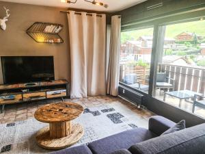 a living room with a couch and a table at Appt les Granges - Vue montagne et village, Centre la Clusaz - AravisTour in La Clusaz