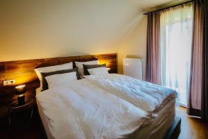 a large white bed in a bedroom with a window at Winzerhaus Rose 