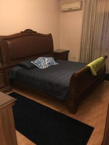 a bedroom with a bed with a wooden headboard at 2 Bed Room Apparment in Amman - Der Ghbar in Amman