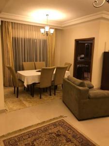 アンマンにある2 Bed Room Apparment in Amman - Der Ghbarのリビングルーム(テーブル、椅子、ソファ付)