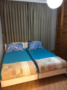 a bedroom with two beds with blue pillows at 2 Bed Room Apparment in Amman - Der Ghbar in Amman