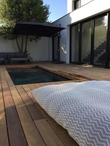 un patio trasero con piscina y terraza de madera en Villa avec piscine bord de mer CARNON en Carnon-Plage