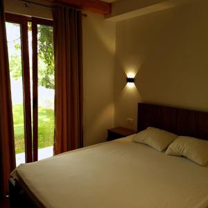a bedroom with a bed with a lamp and a window at Orahovo stone vilas in Virpazar