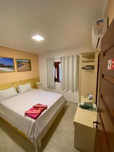 una camera con letto e tavolo con cassettiera di #residencialvillajeri - CASA térrea com VARANDA, máq de lavar, 300m da PRAIA a Jericoacoara