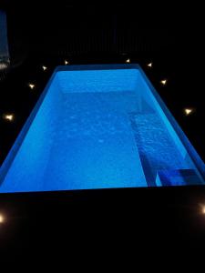una gran piscina azul con luces. en Booroolgunyah Luxury Farm Stay, en Booroolite