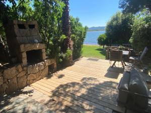 a wooden deck with a view of the water at Maranatha Résidence avec plage privée, piscine chauffée in Porto-Vecchio