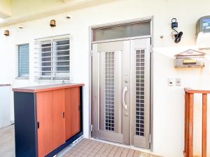 una puerta a una casa con cocina y fregadero en SumiwaHouse, en Yomitan