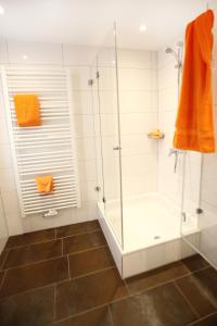 a bathroom with a shower stall and a tub at Hotel Schmidt am Markt in Meppen