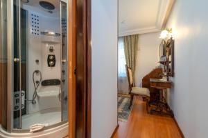 een badkamer met een douche en een glazen deur bij Heritage Hotel Pasike in Trogir