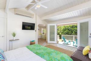 a bedroom with a bed and a balcony at North Shore Garden Studio in Haleiwa