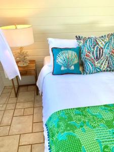 a bedroom with a bed and a table with a lamp at North Shore Garden Studio in Haleiwa