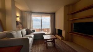 Una sala de estar con un sofá y una ventana grande. en Golf Mar II G 2-1, en Pals