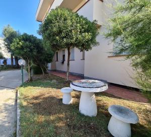 a table and two stools sitting in the grass at Camere al Mare in Lido di Camaiore