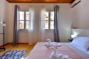 una camera da letto con due cigni su un letto con finestra di Welcome Inn Marlen's House a Città di Corfù