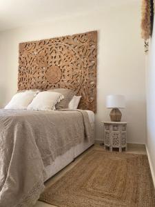 Schlafzimmer mit einem Bett mit einem Kopfteil aus Holz in der Unterkunft Luxury B&B Villa Tauro in Málaga