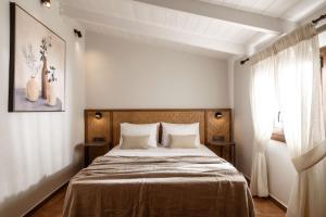 a bedroom with a large bed with two tables at Villa Frontale - Restored Villa with Pool Perfect for 4 Nestled Next to a Traditional Olive Mill and Local Farms Offering Authentic Hospitality and Organic Delights By Villa Mana Gers in Kallithea