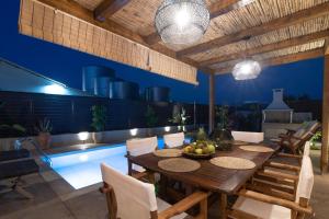 a dining room with a table and a swimming pool at Villa Frontale in Kallithea