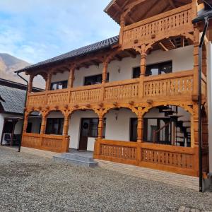 a large wooden building with a wooden deck at La Mona in Bîrsana