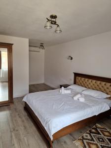 1 dormitorio con 1 cama grande y 2 toallas. en La Mona, en Bîrsana