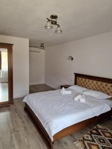 a bedroom with a large bed with two towels on it at La Mona in Bîrsana