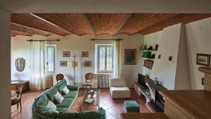 ein Wohnzimmer mit grünen Möbeln und einer Holzdecke in der Unterkunft Podere San Carlo in Siena