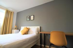 ein Schlafzimmer mit einem Bett, einem Schreibtisch und einem Stuhl in der Unterkunft Hamilton House -3 bed Close to Town, Drive Parking, 2 toilets in Newcastle upon Tyne