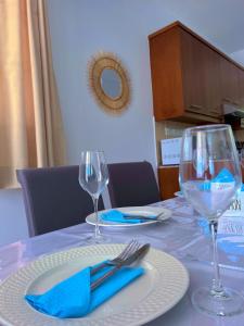 a table with two wine glasses and a blue napkin at 3 Bedroom Coral Bay Beach Seaview Villa I Private Pool in Peyia