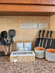 a kitchen counter with knives and utensils on a shelf at 3 Bedroom Coral Bay Beach Seaview Villa I Private Pool in Peyia