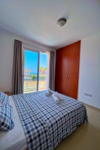 a bedroom with a bed and a large window at 3 Bedroom Coral Bay Beach Seaview Villa I Private Pool in Peyia