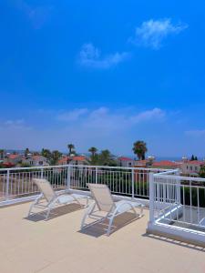 dos sillas sentadas en una terraza con barandilla en 3 Bedroom Coral Bay Beach Seaview Villa I Private Pool, en Peyia