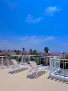 two chairs sitting on a deck with a railing at 3 Bedroom Coral Bay Beach Seaview Villa I Private Pool in Peyia +26 photos
