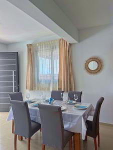 a dining room with a white table and chairs at 3 Bedroom Coral Bay Beach Seaview Villa I Private Pool in Peyia