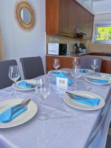 a table with wine glasses and blue napkins on it at 3 Bedroom Coral Bay Beach Seaview Villa I Private Pool in Peyia