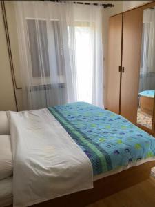 um quarto com uma cama com um cobertor azul em Obiteljska kuća u centru Posušja em Posusje