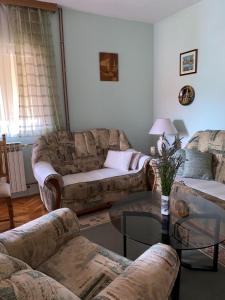 a living room with two couches and a glass table at Obiteljska kuća u centru Posušja in Posušje
