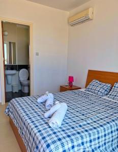 a bedroom with a bed with blue towels on it at 3 Bedroom Coral Bay Beach Seaview Villa I Private Pool in Peyia
