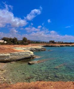 a beach with clear blue water and rocks at 3 Bedroom Coral Bay Beach Seaview Villa I Private Pool in Peyia