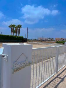 a white fence with aania sign on it at 3 Bedroom Coral Bay Beach Seaview Villa I Private Pool in Peyia