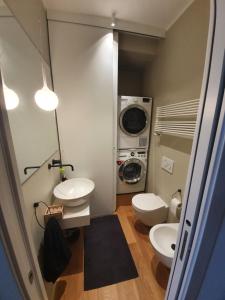 een badkamer met 2 toiletten en een wasmachine bij Penthouse F8 - Panoramic terrace, view Two Towers in Bologna