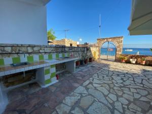 a bench on a stone wall with the ocean in the background at AngelView Apartments in Himare
